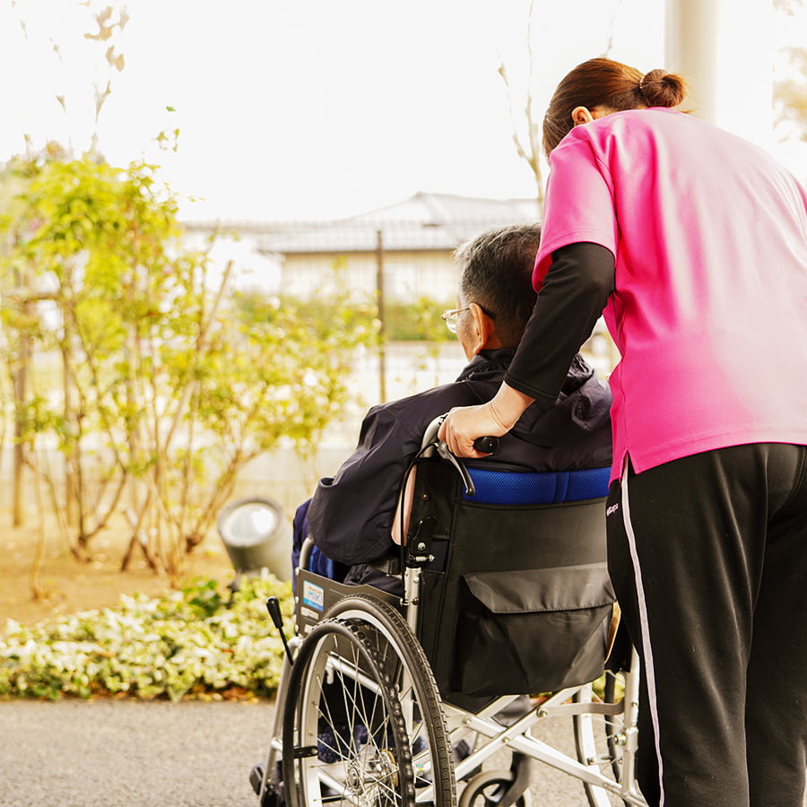 車椅子にのっている利用者に寄り添う職員
