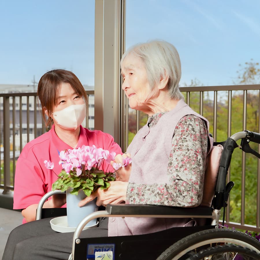 花を大切に持つ利用者様と職員