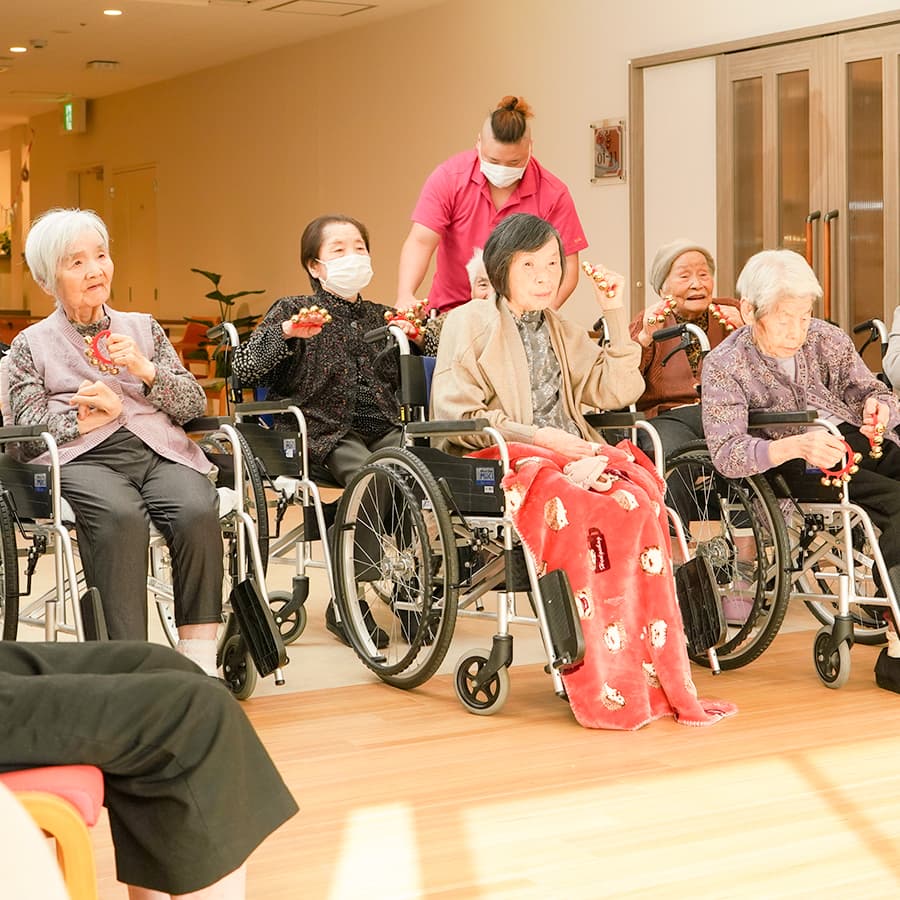 車椅子に乗ってフラダンスを踊る様子を見る