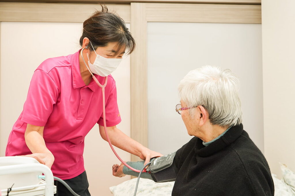 看護師が高齢女性の健康をチェックしている様子
