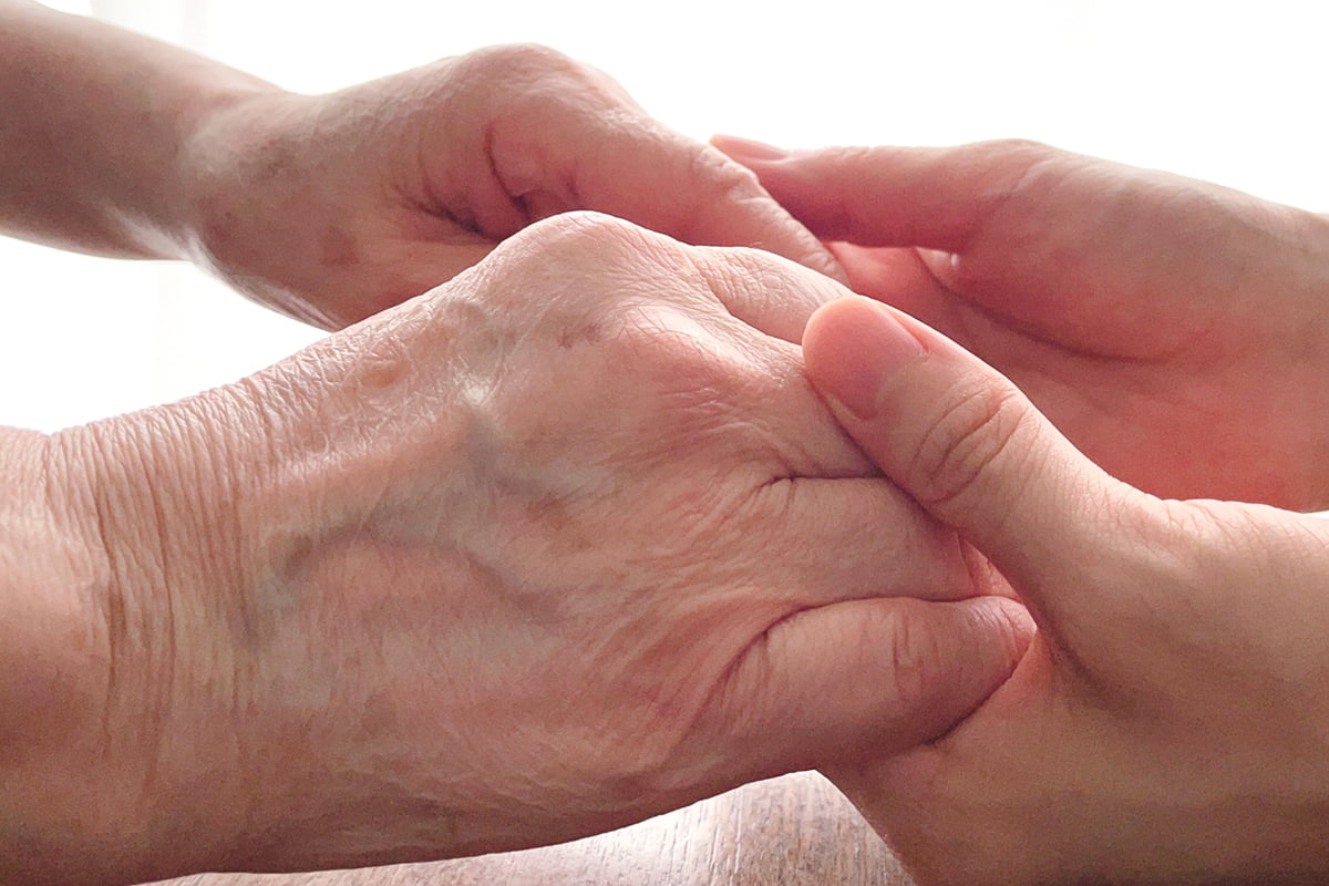 高齢者の手と介護者の手
